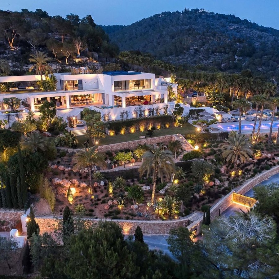 Private gated villa estate in Ibiza lit at dusk